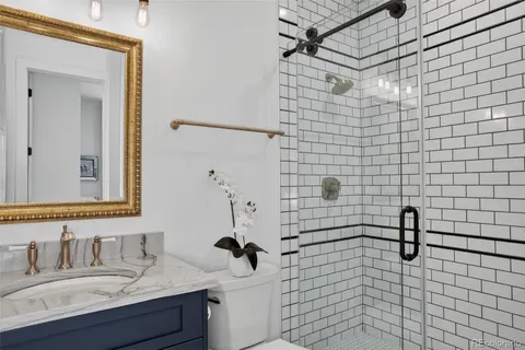a bathroom with a sink shower and a mirror