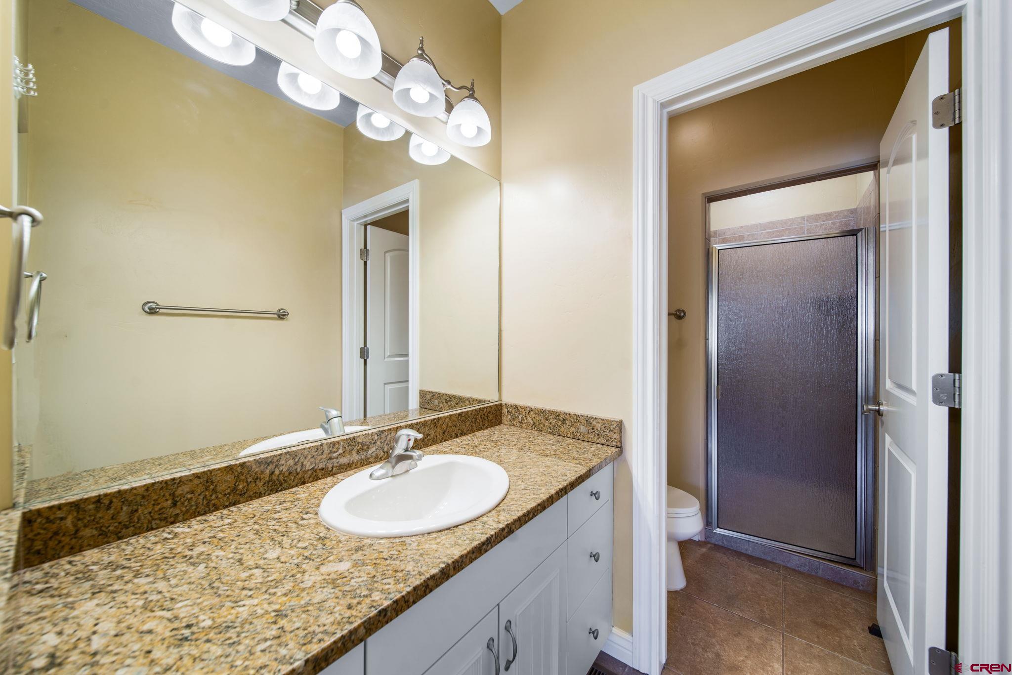 1630 Gateway Drive, Unit 3 Cortez, CO 81321 - Photo 17 of 34 a bathroom with a granite countertop sink and a mirror