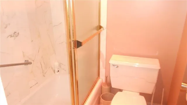 a bathroom with a toilet and a shower curtain
