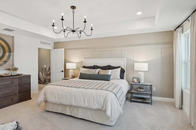 a bedroom with bed and a chandelier