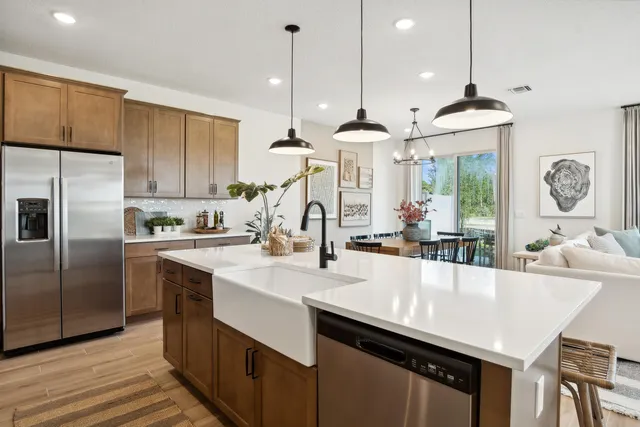 a kitchen with granite countertop a sink a center island stainless steel appliances and cabinets