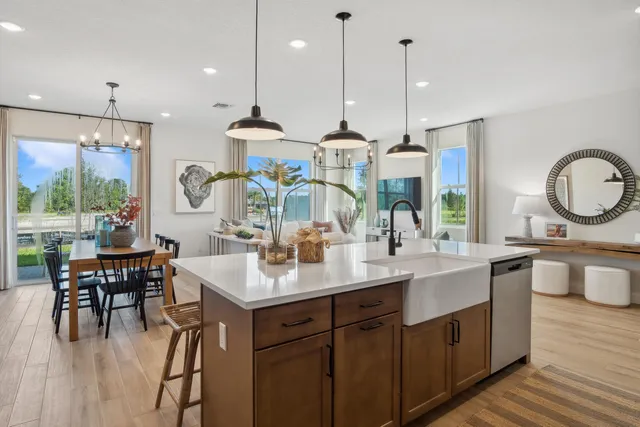 a kitchen with stainless steel appliances granite countertop a sink a stove and a wooden floors