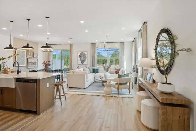 a living room with furniture a large window and wooden floor