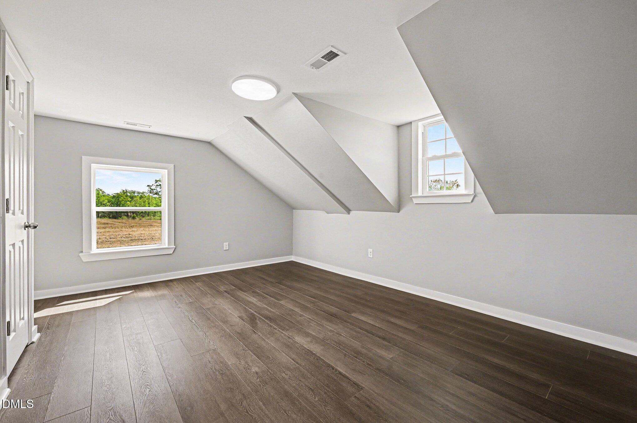 1325 Charlie Carr Road Roxboro, NC 27574 - Photo 27 of 31 an empty room with wooden floor and windows