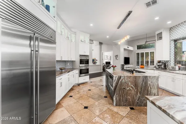 an outdoor living room with furniture and a flat screen tv