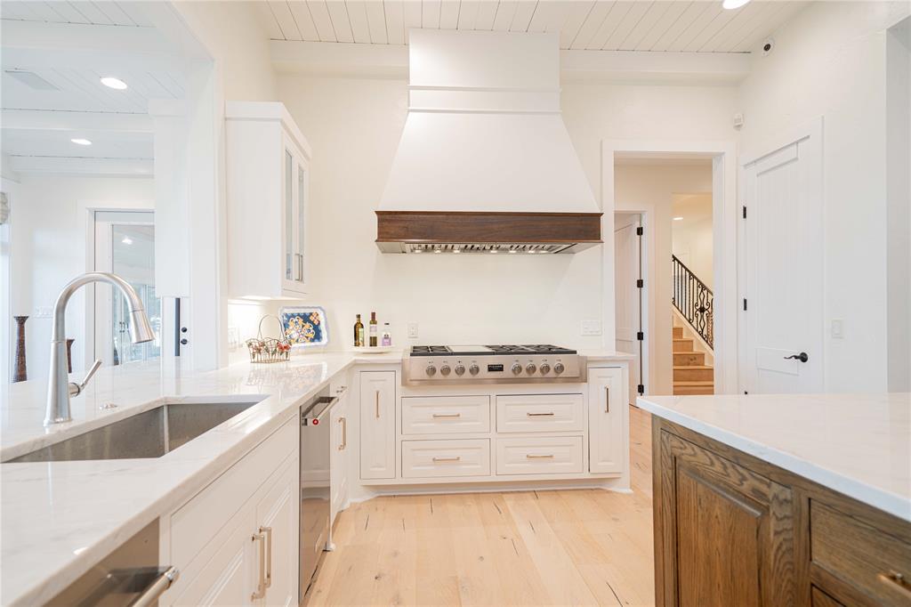 582 Windy Point Mount Vernon, TX 75457 - Photo 19 of 38 Kitchen featuring appliances with stainless steel finishes, light wood finished floors, premium range hood, white cabinetry, and recessed lighting
