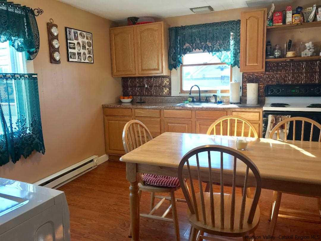 22 Wallkill Avenue Wallkill, NY 12589 - Photo 14 of 26 a kitchen with a table chairs and a refrigerator