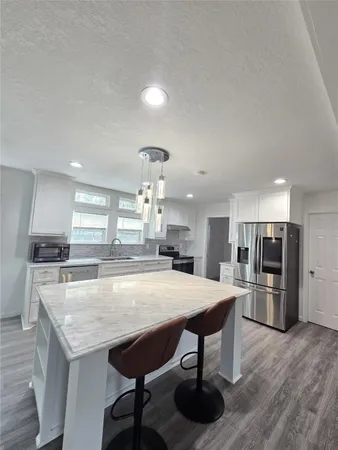 a large kitchen with a table and chairs