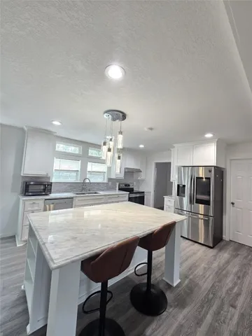 a large kitchen with a table and chairs