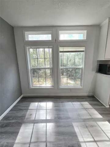 a view of empty room with windows and chandelier