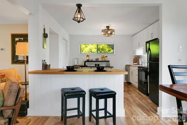 a kitchen with a table chairs refrigerator and window