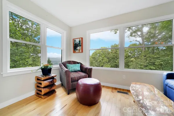 a living room with furniture and floor to ceiling windows