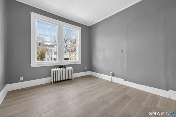 a view of an empty room with wooden floor