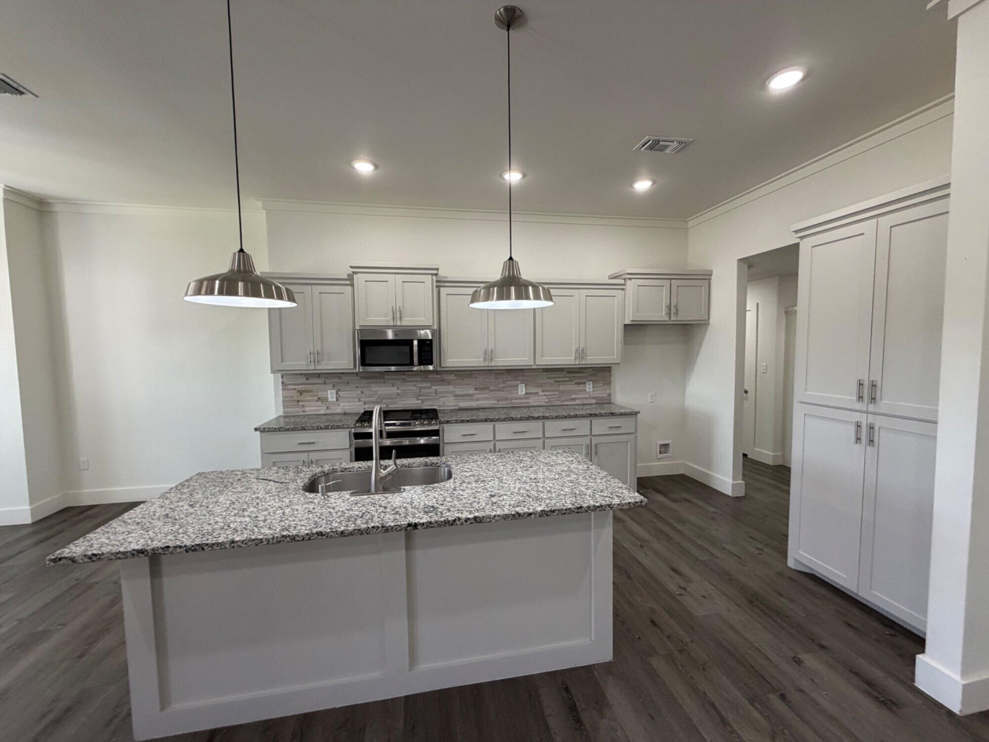 405 Ranger Street Wolfforth, TX 79382 - Photo 6 of 19 a kitchen with kitchen island a counter top space a sink stainless steel appliances and cabinets