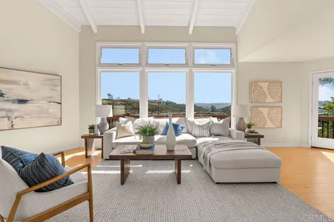 a bedroom with a bed a large window with outer view and couch