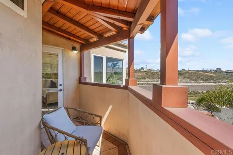 a view of balcony with chairs and wooden fence