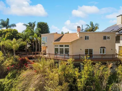 an aerial view of a house with a yard and large tree