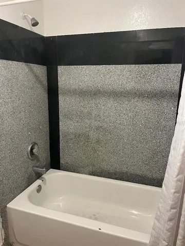 a bathroom with a toilet and a shower curtain
