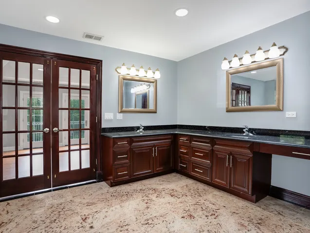 a spacious bathroom with a granite countertop sink and a large mirror