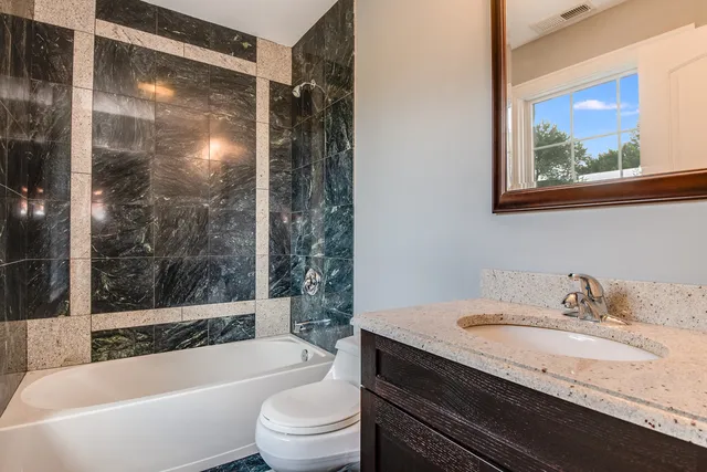 a bathroom with a granite countertop sink toilet and bathtub