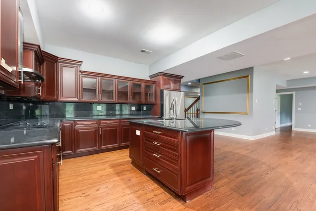 a kitchen with stainless steel appliances granite countertop a stove and a wooden cabinets
