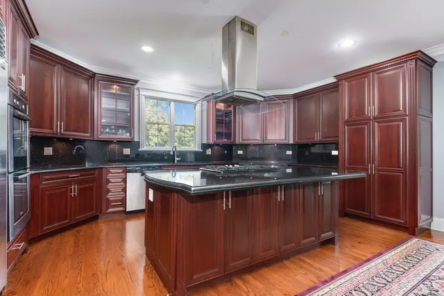 a kitchen with stainless steel appliances granite countertop wooden cabinets a stove top oven a sink and dishwasher