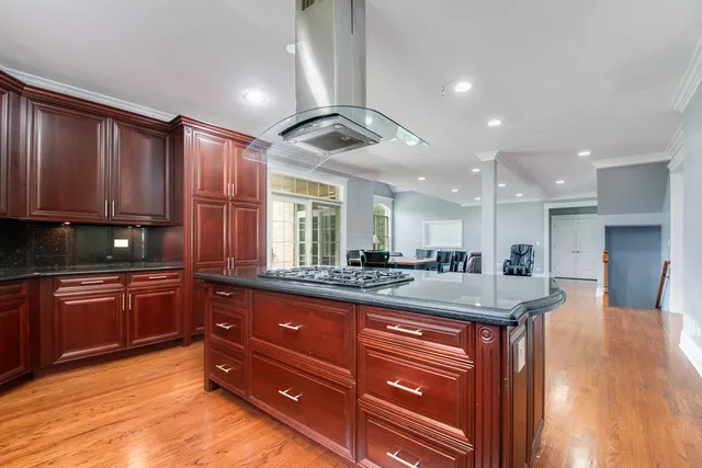 a kitchen with kitchen island granite countertop a sink stainless steel appliances and cabinets