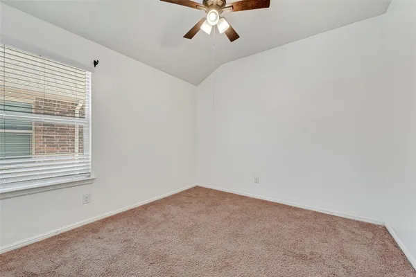 a view of a room with a ceiling fan and window