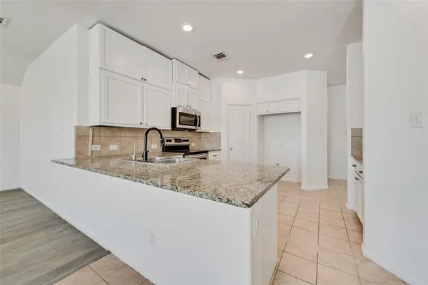a kitchen with stainless steel appliances granite countertop a sink a stove and cabinets