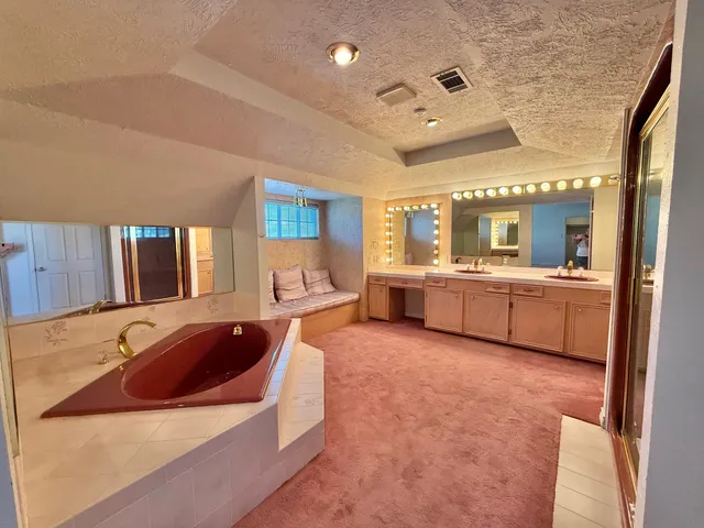 a spacious bathroom with a tub double vanity sink and mirror