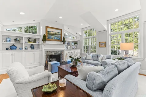 a living room with furniture fireplace and a large window