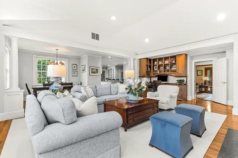 a living room with furniture kitchen view and a window