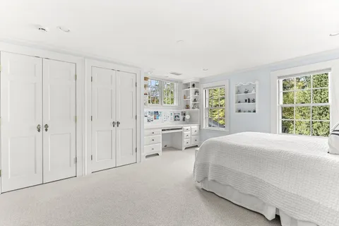 a spacious bedroom with a bed and a large window