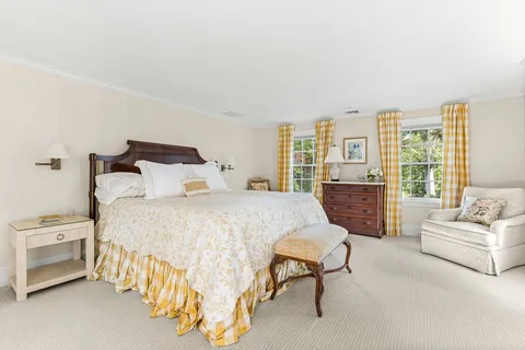 a spacious bedroom with a bed a couch and a large window