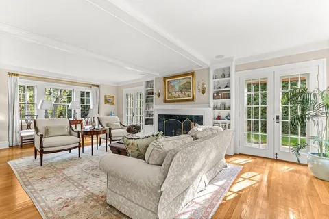 a living room with furniture large window and a fireplace