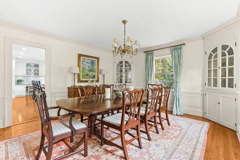 a dining room with furniture a chandelier and wooden floor