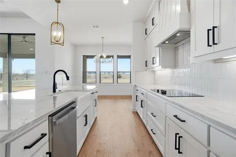 a large kitchen with granite countertop a stove and a sink
