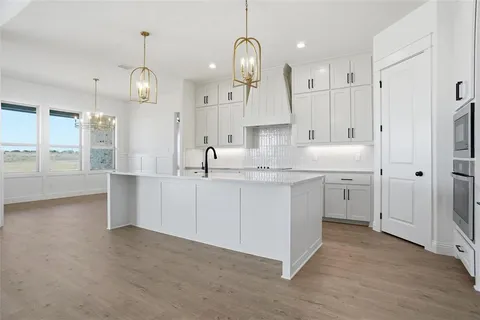a kitchen with kitchen island white cabinets and refrigerator