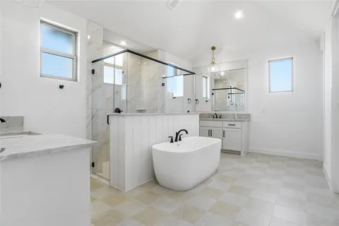 a spacious bathroom with a sink a mirror and a bathtub