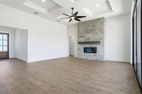 an empty room with fireplace fan and windows