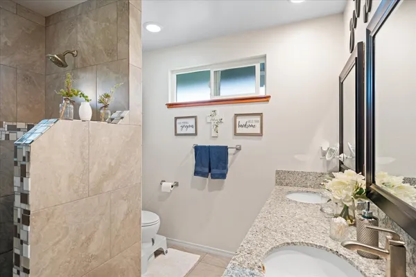 a bathroom with a granite countertop sink and a mirror