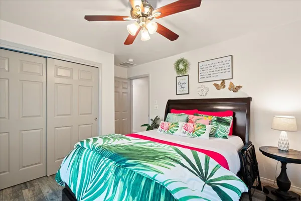 a bedroom with a bed and a lamp on dresser