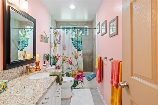 a bathroom with a granite countertop tub sink and mirror