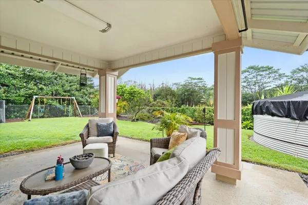 a view of a patio with couches potted plants and a big yard