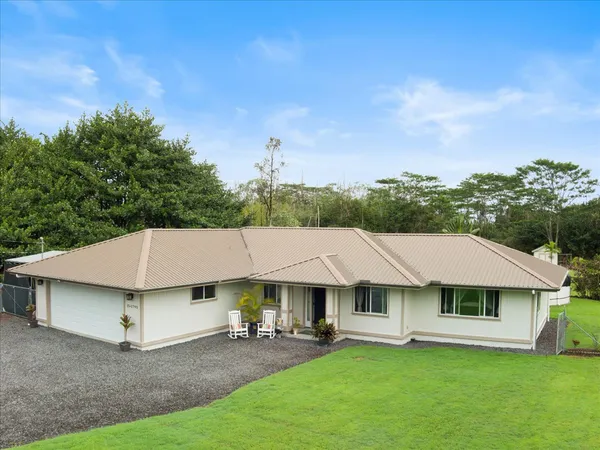 a front view of a house with a garden and yard