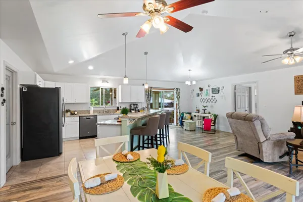 a living room with stainless steel appliances kitchen island granite countertop furniture and a dining table
