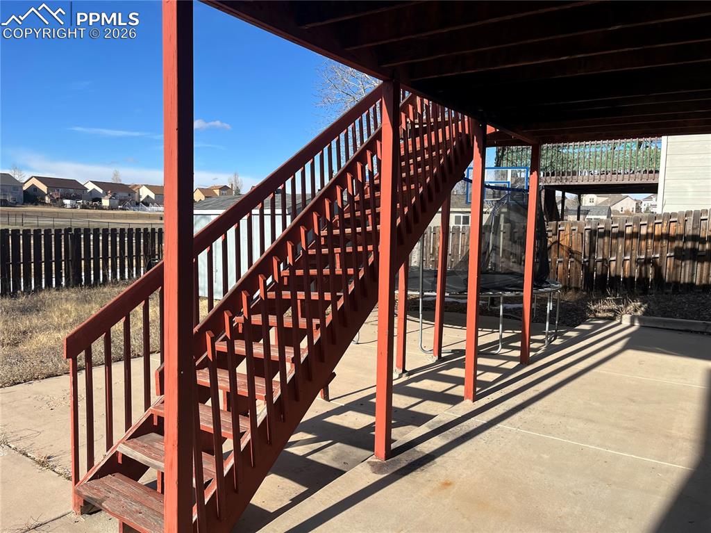 7860 Gladwater Road Peyton, CO 80831 - Photo 6 of 22 a view of staircase with a floor to ceiling window with wooden fence