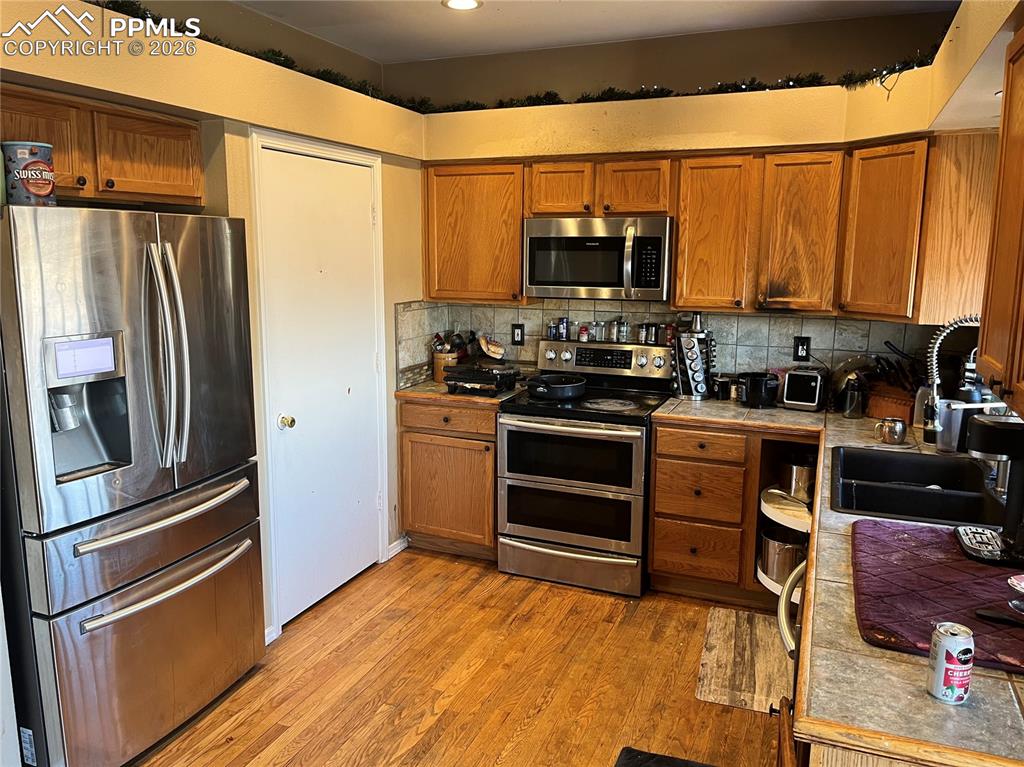 7860 Gladwater Road Peyton, CO 80831 - Photo 8 of 22 a kitchen with stainless steel appliances a refrigerator stove and microwave