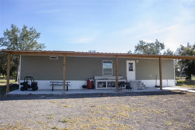 a backyard of a house with table and chairs