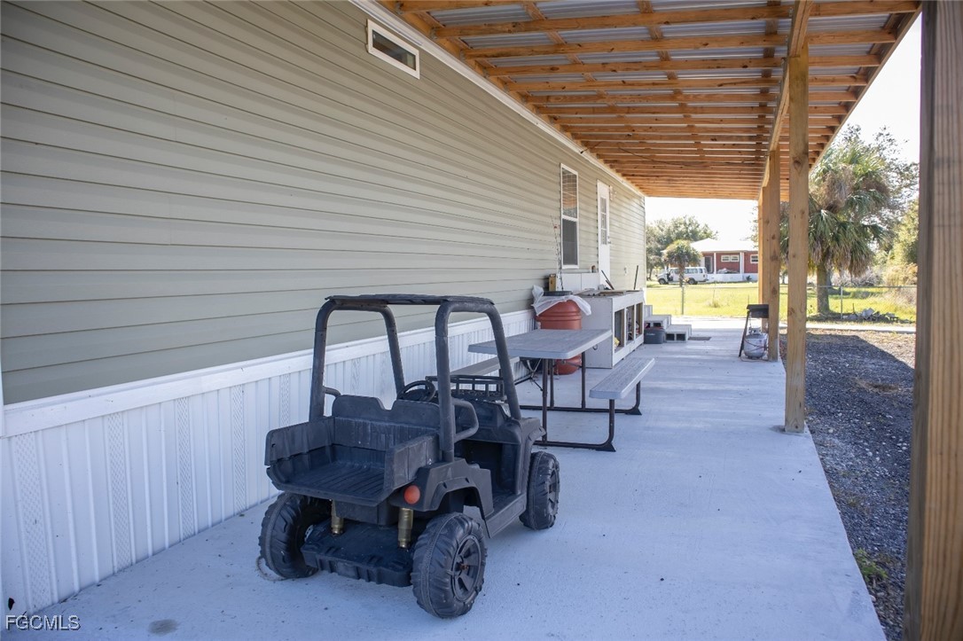720 North Estribo Street Clewiston, FL 33440 - Photo 19 of 39 a view of a patio with table and chairs and couches with wooden roof and stairs